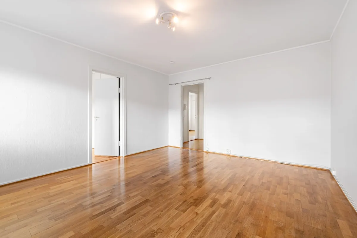Clean empty rental unit with hardwood floors ready for tenant