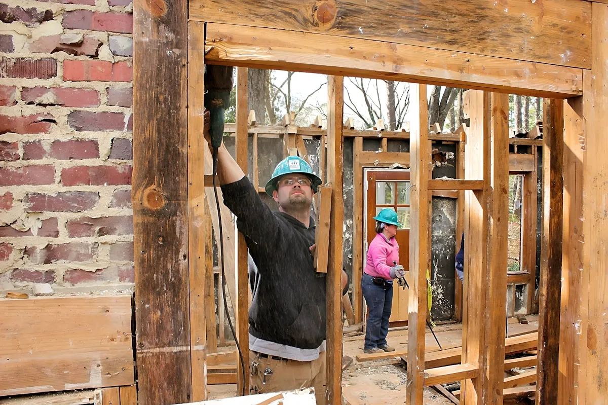 Interior demolition with exposed framing and brick